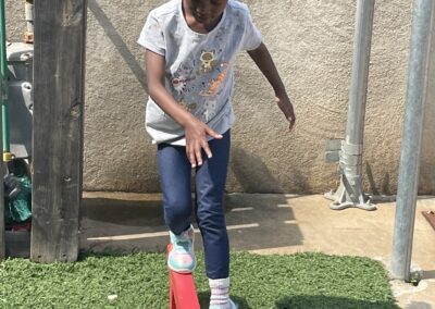 a young girl is playing on a red wooden platform