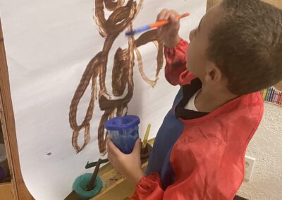 a young boy drawing on a white board