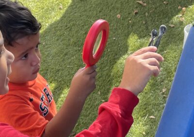 two boys playing with a magnifying glass